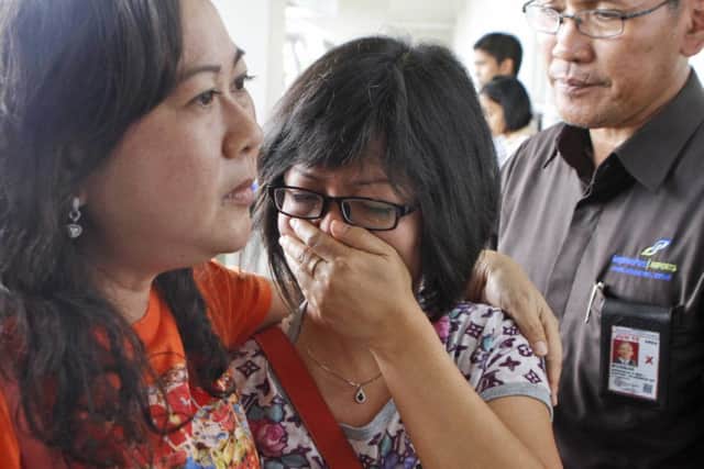 A relative of Air Asia flight QZ8501 passengers weep as she waits for the latest news on the missing jetliner.