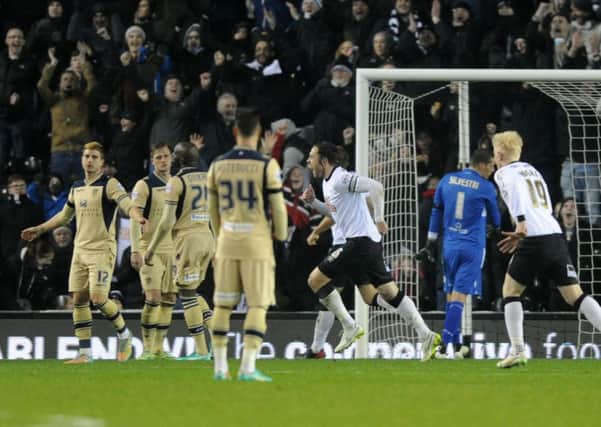Leeds United players stand dejected as Derby County celebrate Jake Buxtons goal in the home sides 2-0 Championship win last night (Picture: Bruce Rollinson).