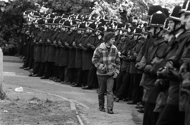 1984: A picket inspecting a line of police officers outside the Orgreave coking plant near Rotherham.