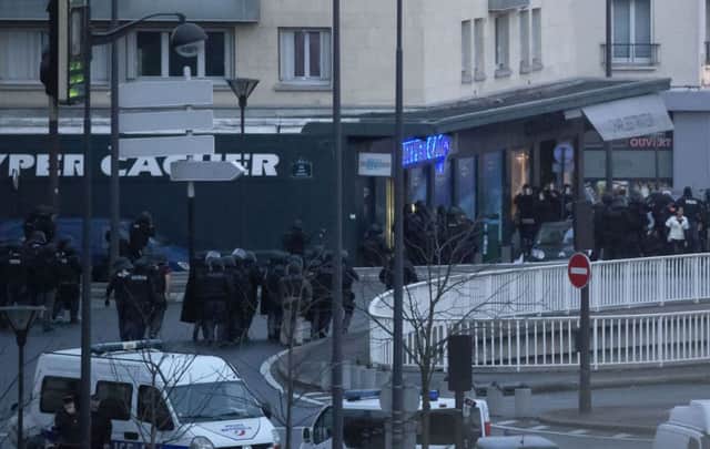 French police officers storm a kosher grocery in Paris.  (AP Photo/Michel Euler)