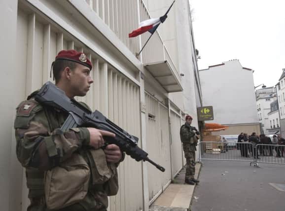 Soldiers stand guard outside a synagogue in Paris