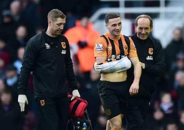 James Chester is helped off with a disclocated shoulder at West Ham yesterday, adding to the growing selection concerns of Hull City manager Steve Bruce (Picture: Adam Davy/PA).