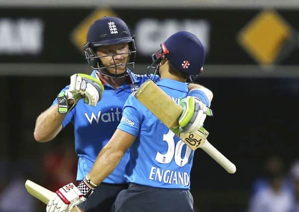 England's Ian Bell, left, and James Taylor, right, celebrate after England won the one day International cricket match against India in Brisbane, Australia. (AP Photo/Tertius Pickard)