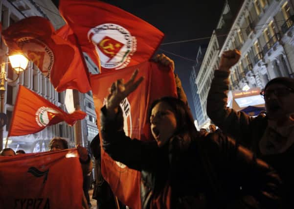 Supporters of left-wing Syriza party react after exit poll results in Athens, Sunday, Jan. 25, 2015. A senior official in Greece's governing conservatives has conceded defeat to the radical left Syriza party in Sunday's national elections.