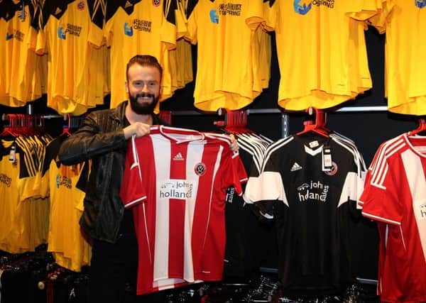 John Brayford beams with delight as he holds aloft the Sheffield United shirt he is eager to wear again (Picture: Martyn Harrison).