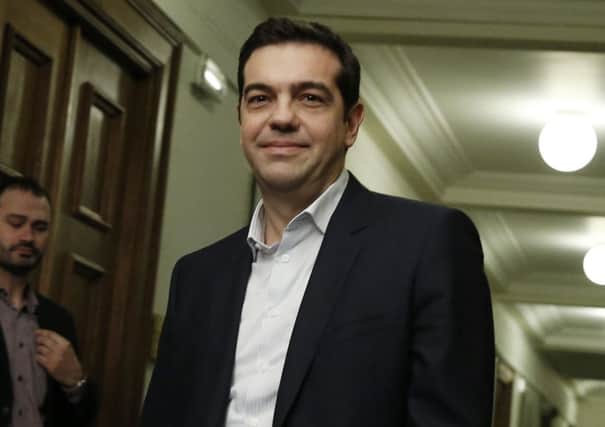 Greece's prime minister Alexis Tsipras arrives for his first cabinet meeting yesterday. His government wants to  end budget cuts and tax rises