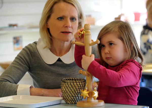 Helen Gration, watching Isabella Lane, three, playing at the Montessori Nursery at Strensall near York.