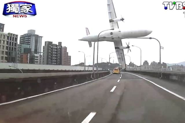 A commercial aeroplane clipping an elevated roadway just before it careened into a river in Taipei, Taiwan