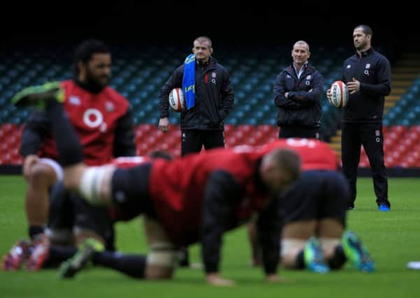 GAME ON: England head coach Stuart Lancaster (centre) with coaches Graham Rowntree (left) and Andy Farrell (right) watch the players warm up at the Millennium Stadium. Picture: Nick Potts/PA.