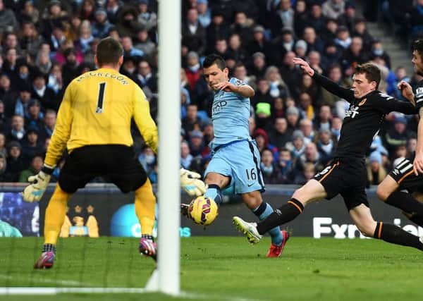 Manchester City's Sergio Aguero has his shot blocked by Hull City's Andrew Robertson (second right).
