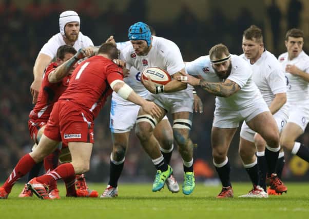 England's James Haskell (centre) is tackled by Wales' Gethin Jenkins (left)