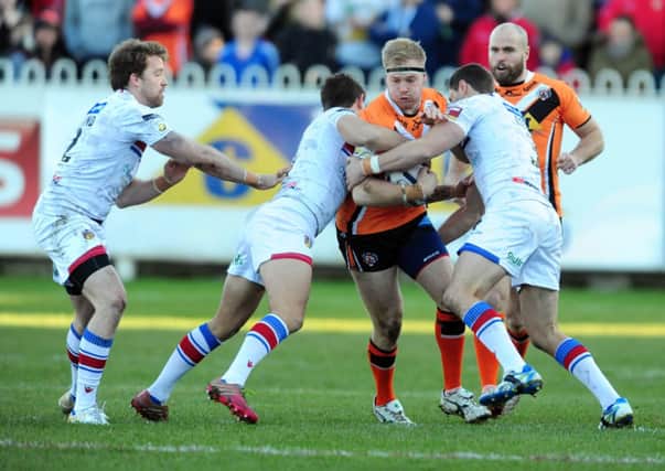 Castleford Tigers Oliver Holmes is tackled by Wakefield Wildcats' Danny Kirkmond, Tim Smith, and Dean Collis (Picture: James Hardisty).