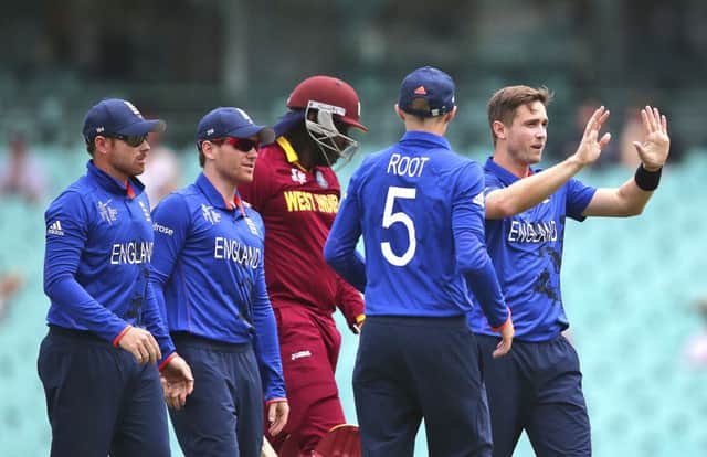 West Indies batsman Chris Gayle walks back to the pavilion after being dismissed for a first-ball duck by England's Chris Woakes, far right. Picture: AP/Rob Griffith.