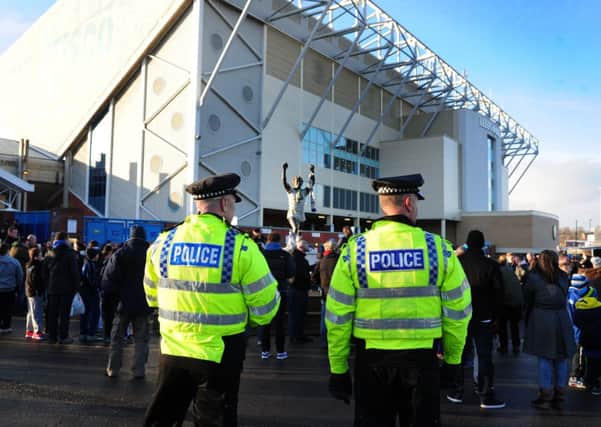 Police keep a watch on Leeds fans outside Elland Road. Picture by Tony Johnson