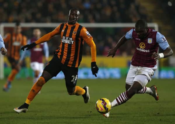 Hull City's Dame N'Doye (centre) and Aston Villa's Fabian Delph an  Jores Okore (right)