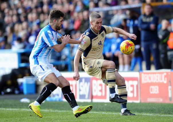 Leeds United's Steve Morison battles with Huddersfield's Tommy Smith.