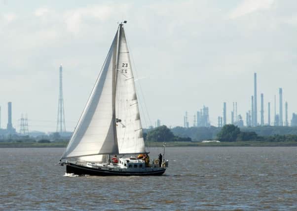 A yacht on the River Humber passes the Total Lindsey Oil Refinery in North Lincolnshire, as it announces that capacity is to be cut by 50 per cent.