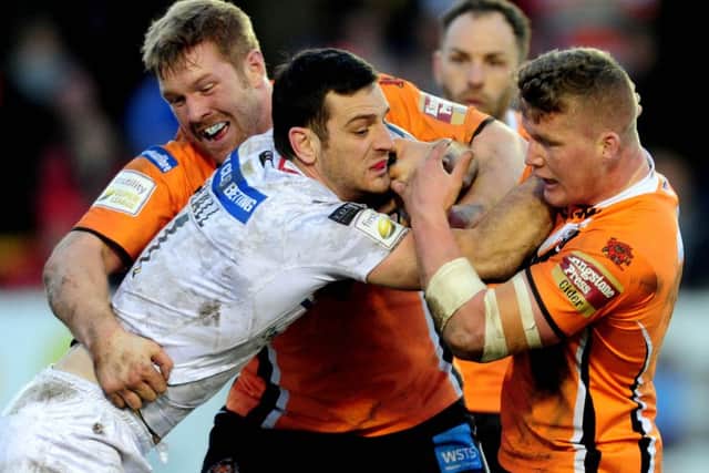 Wakefield Wildcats Craig Hall, being held back by Castleford Tigers Ryan Boyle, and Adam Milner.