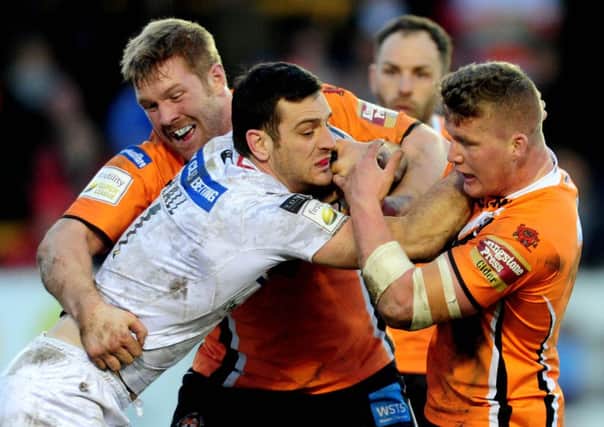 Wakefield Wildcats Craig Hall, being held back by Castleford Tigers Ryan Boyle, and Adam Milner.