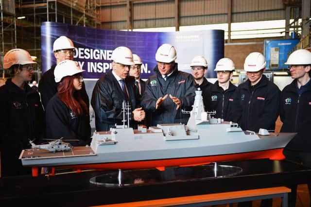 Prime Minister David Cameron (centre) looks at a model of the Type 26 Global Combat Ship during a visit to BAE Systems Govan shipyard in Glasgow, Scotland, where he announced a £859 million investment in the next generation of Royal Navy frigates, sustaining 1,700 jobs across the country. PRESS ASSOCIATION Photo. Picture date: Friday February 20, 2015. Cameron said the money will be spent on developing the Type 26 warship, which will be built on the Clyde in Scotland. See PA story POLITICS Shipbuilding. Photo credit should read: Jeff J Mitchell/PA Wire