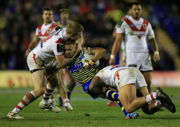 Warrington's Kevin Perry is tackled by St George-Illawarra's Joel Thompson and Tyson Frizel. Picture: Mike Egerton/PA.