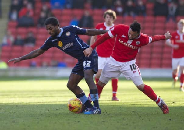 Barnsley's Kane Hemmings tangles with Anthony Grant.