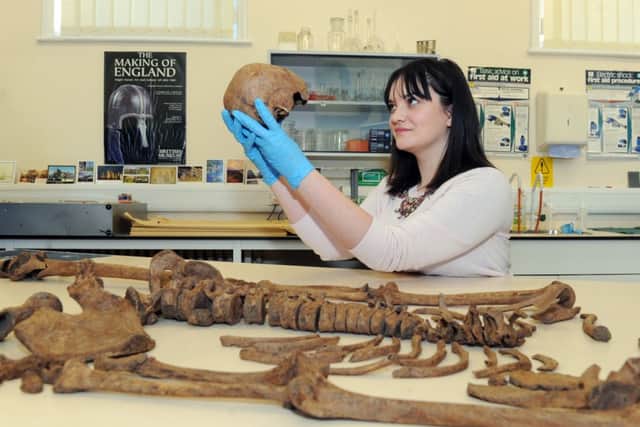 Ruth Whyte, an archaeologist  for the York Archaeological Trust  looking at the skull of one of the 12 skeletons found in the city.