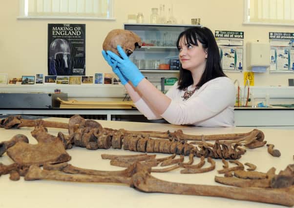 Ruth Whyte, an archaeologist  for the York Archaeological Trust  looking at the skull of one of the 12 skeletons found in the city.