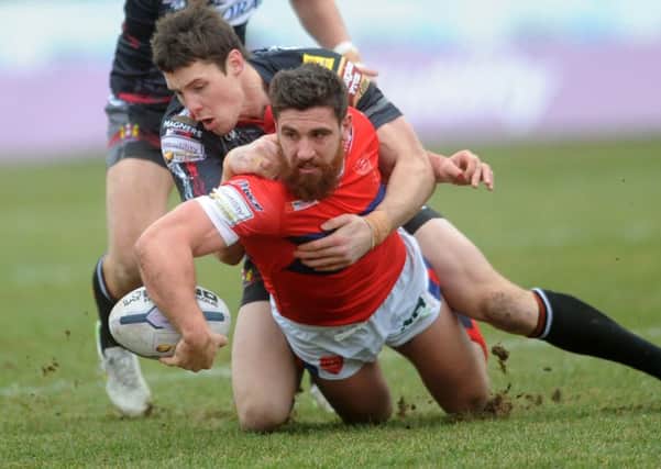 Hull Kingston Rovers' Tyrone McCarthy is tackled by Wigan's Joel Tomkins. (Picture: Jonathan Gawthorpe).