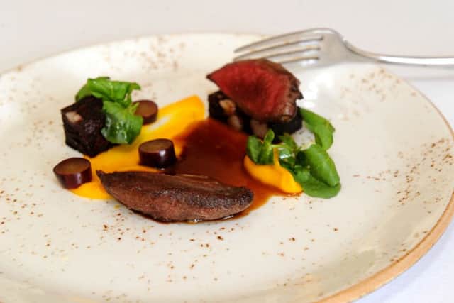 A starter of seared wood pigeon, root vegetable puree, black pudding and pickled grapes