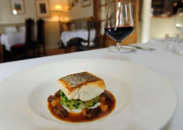 A main course of  east coast hake, slow cooked oxtail, creamed celeriac, savoy cabbage and cooking juices  at The Buck Inn at Maunby near Thirsk.