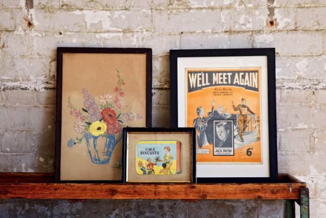 A selection of framed 40s items inclduing an embroidery sample, sheet music and a biscuit advert