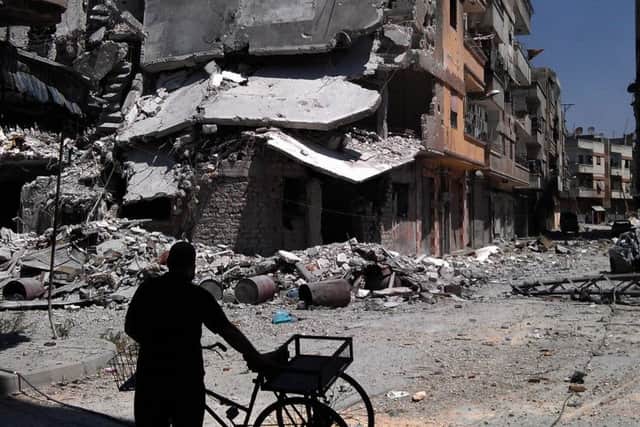 A man looks at destroyed buildings in Khaldiyeh, Homs, Syria.