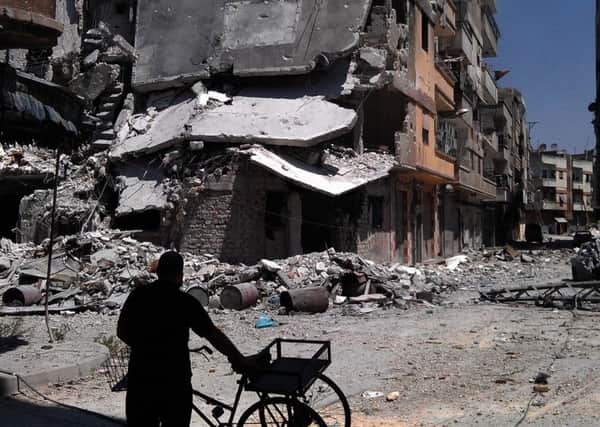 A man looks at destroyed buildings in Khaldiyeh, Homs, Syria.