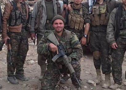 Konstandinos Erik Scurfield poses with Kurdish fighters and foreign volunteers. Picture: Jordan Matson