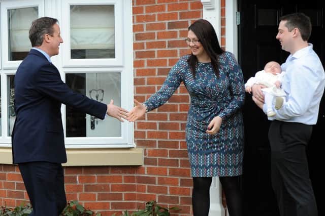 David Cameron meets home owners Lee Cooper and Christine Billings with baby Emily during a visit to Bellway homes development in Cannock, West Midlands.