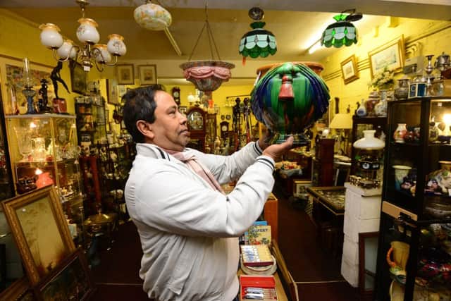 Richard Uddin in Langton's Antiques and Collectables with a piece of ceramic.