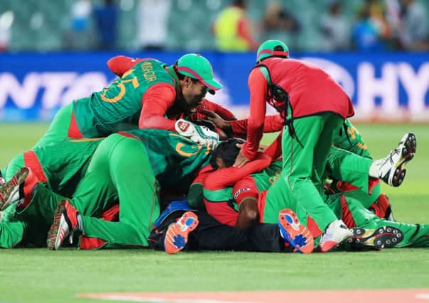 Bangladesh players celebrate after they defeated England by 15 runs in their Cricket World Cup Pool A match in Adelaide. (AP Photo/James Elsby)