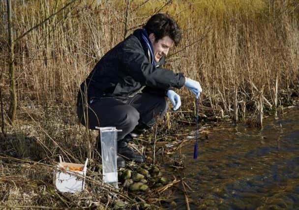 Dr Chris Dennis taking samples from a pond