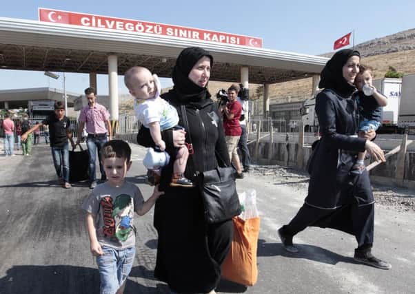 Syrian refugees pass through the Turkish Cilvegozu gate border,
