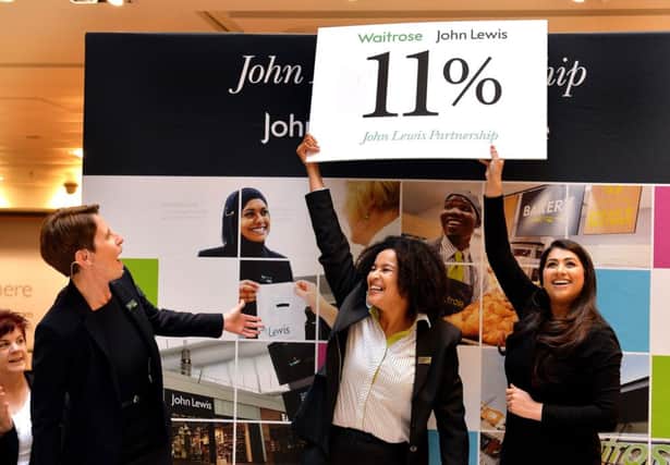 Store manager Karen Lord, Priscilla Aldridge and Nadia Hassan reveal the annual bonus of 11% which partners working for the John Lewis Partnership will receive, at John Lewis in Oxford Street, London.