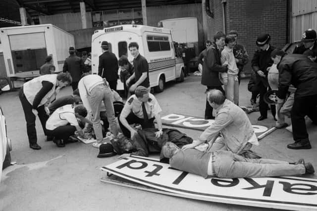 Injured fans lie on advertising boards which were used as makeshift stretchers.