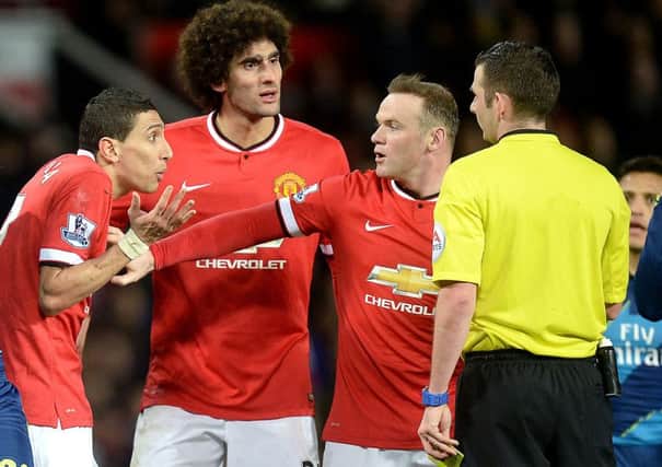 Manchester United's Angel Di Maria (left) is held by teammate Wayne Rooney as he protests to referee Michael Oliver before being sent off during the FA Cup, Sixth Round match at Old Trafford, Manchester.