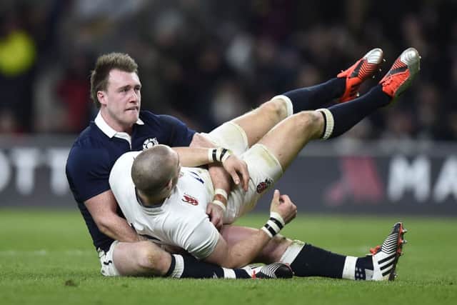 Scotland's Stuart Hogg holds up England's Mike Brown after he runs in to score a try which was disallowed for a forward pass