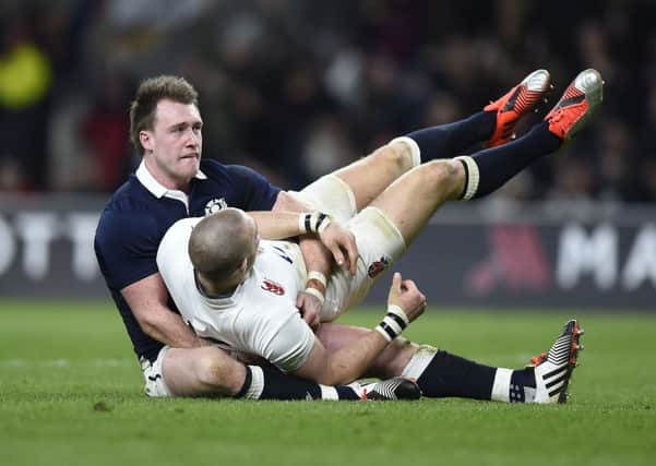 Scotland's Stuart Hogg holds up England's Mike Brown after he runs in to score a try which was disallowed for a forward pass