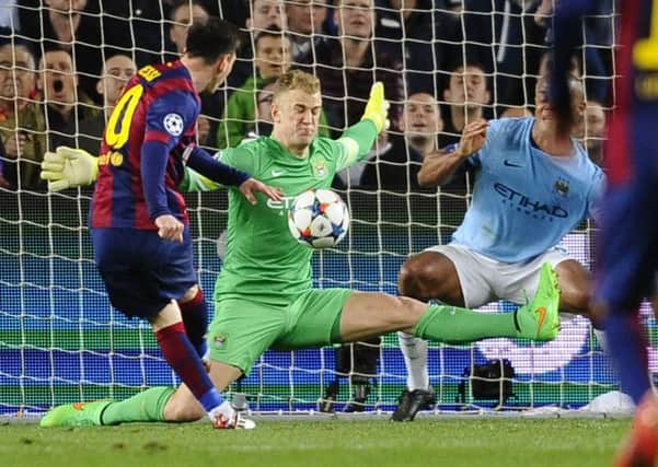 Manchester City's goalkeeper Joe Hart, center, and Manchester City's Vincent Kompany, right, save against Barcelona's Lionel Messi, left.