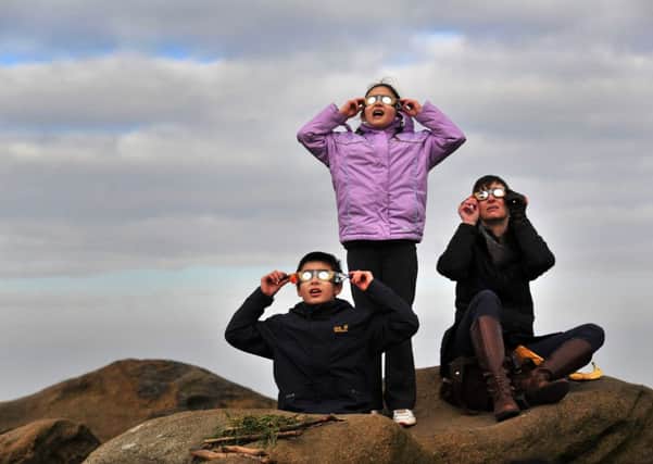 The Kraam family from Menston watching the eclipse, through the clouds from Otley Chevin.   Picture: Bruce Rollinson