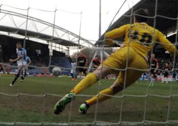 Fulham's Marcus Bettinelli saves Huddersfield's Nahki Wells's first penalty.