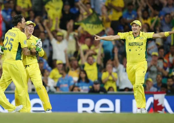 Australia's Mitchell Johnson, left, celebrates with Brad Haddin as Shane Watson, right, runs in after taking the wicket of India's Virat Kohli. Picture: AP.
