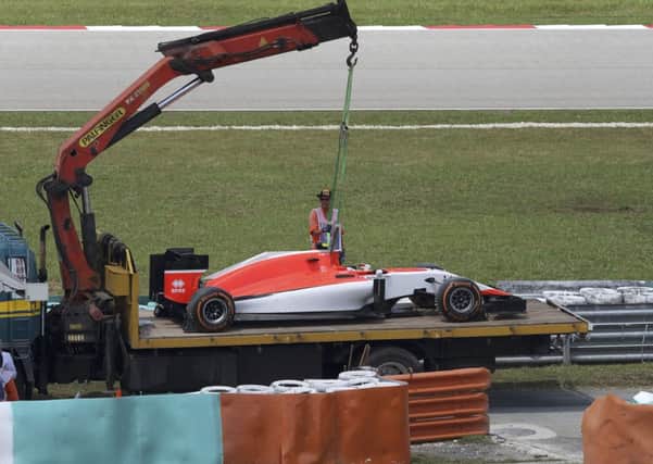 The car of Manor driver Roberto Merhi of Spain is removed after heading into the gravel trap during the second practice session of the Malaysian Formula One Grand Prix in Sepang. (AP Photo/Thomas Lam)